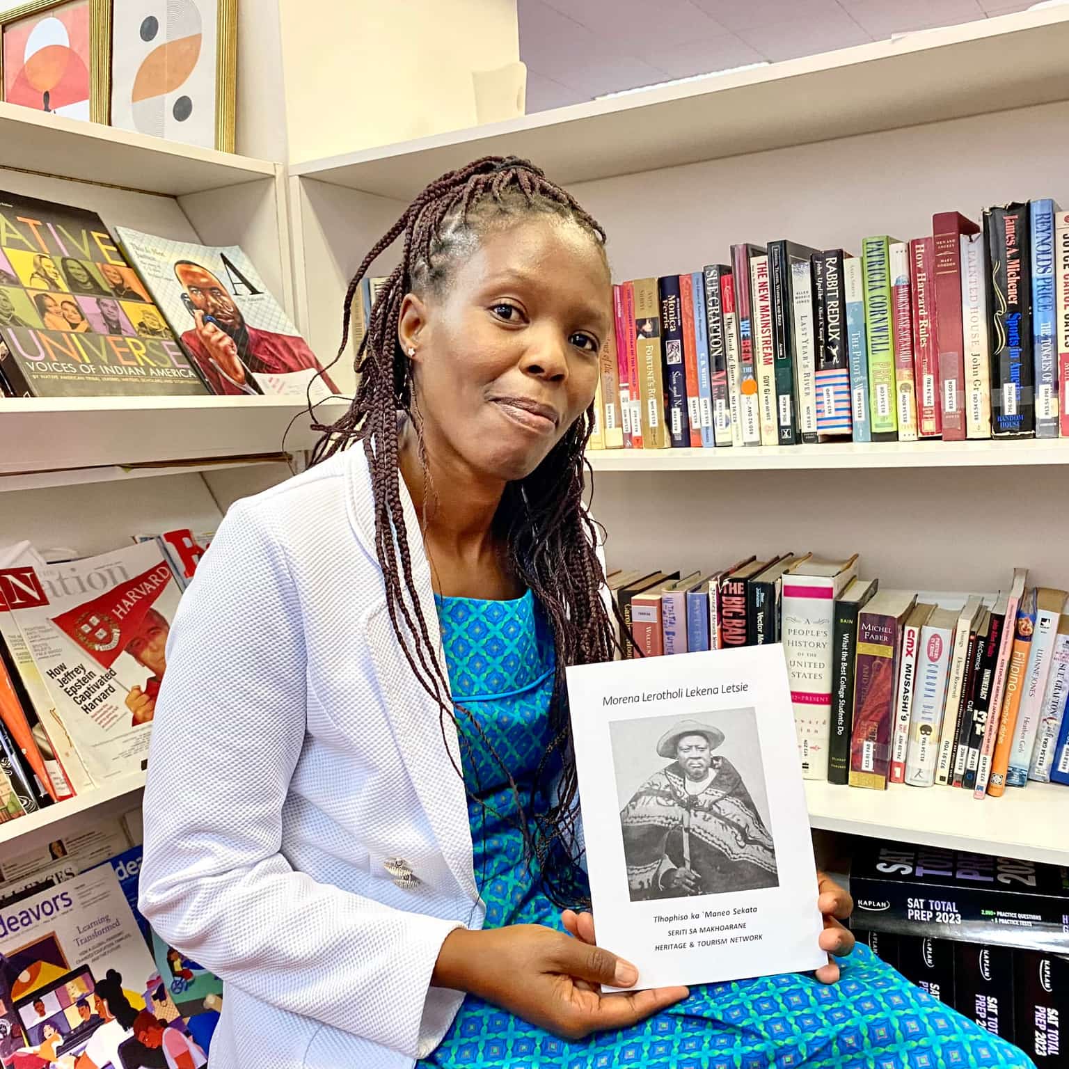 Author and researcher holding a book about Morena Lerotholi Lekena Letsie