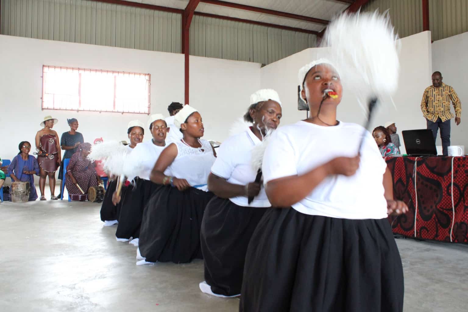 Women performing a traditional Basotho dance in white and black attire at the SSM official launch